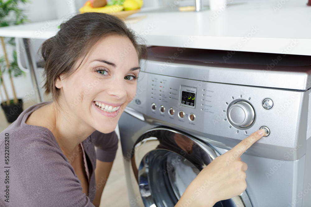 happy woman housewife next to a washing machine happy woman housewife next to a washing machine