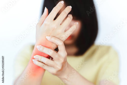Woman's hands are painful due to lifting heavy objects or symptoms of office syndrome.