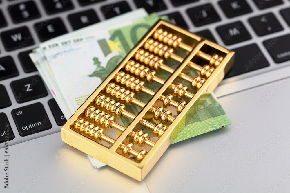 Euro notes and gold beads on the computer keyboard Euro notes and gold beads on the computer keyboard