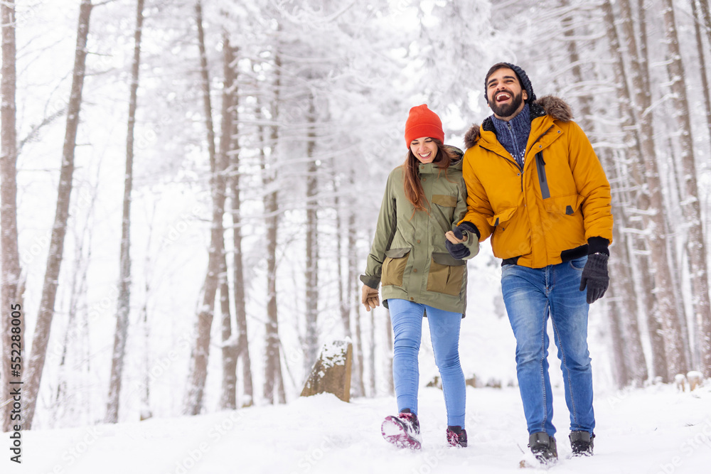 Couple taking a walk in the snow while on winter vacation