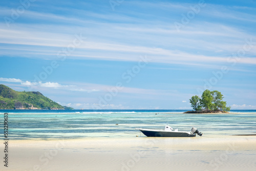 Landscape with a boat. Anse Source d Argent  La Digue Seychelles. Picturesque paradise beach. white sand palm trees turquoise water