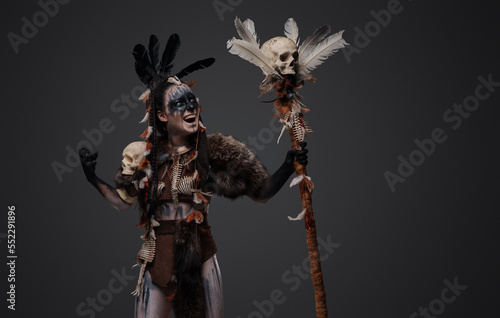 Portrait of angry necromancer dressed in fur holding staff with skull.