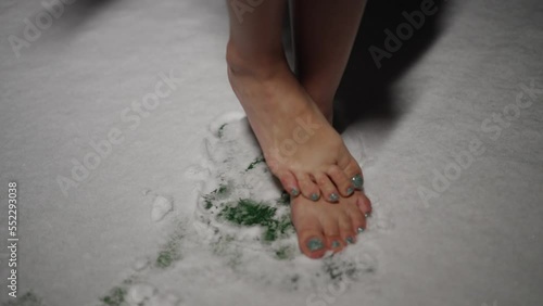 Barefoot woman shivering from the cold while standing in the snow