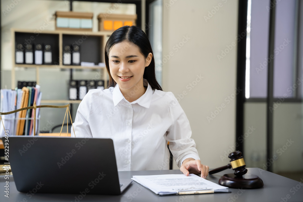Justice and law concept. Female judge in office with the gavel working with digital tablet computer docking keyboard. Justice and law concept. Female judge in office with the gavel working with digital tablet computer docking keyboard.