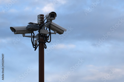 Outdoor security cameras on a pole against the sky