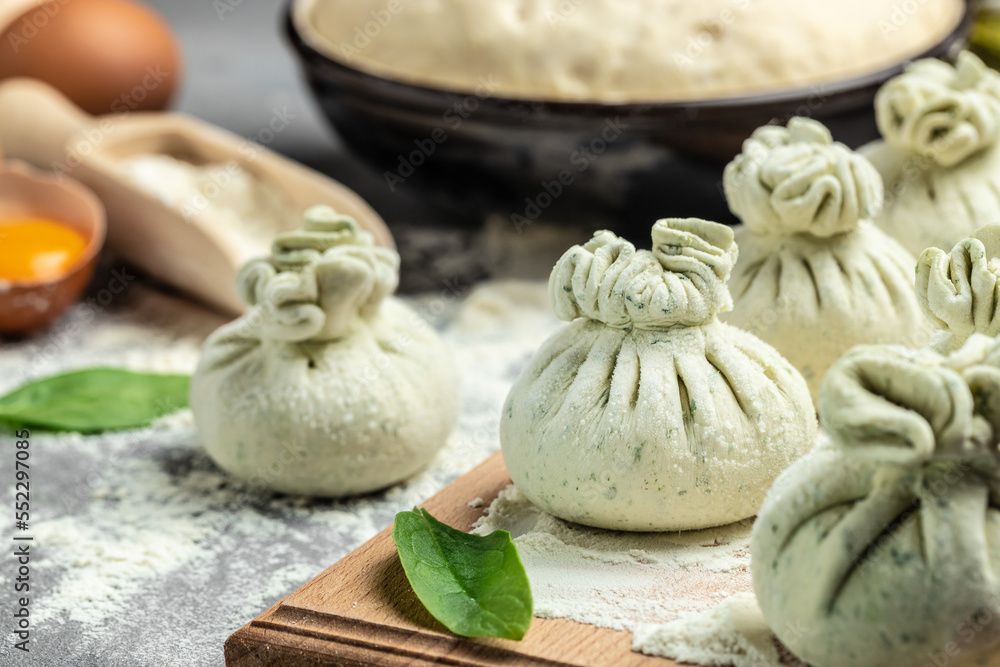 Fototapeta premium cooking Khinkali with cheese and spinach. Raw semi-finished products dumplings. National Georgian cuisine. place for text, top view