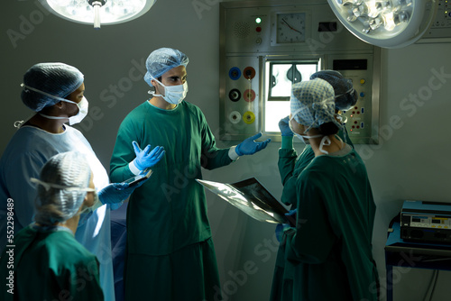 Diverse group of male and female surgeons in discussion, in operating theatre before operation