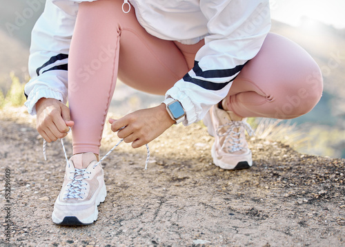 Shoe, hand and woman tie lace for fitness, sport and run in nature for exercise and training workout. Athletic, athlete and footwear of a female sports runner prepare for running marathon outside