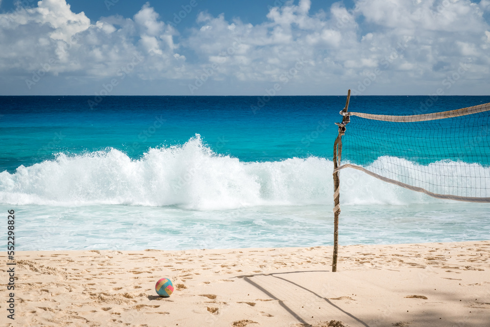 Volleyball net on tropical beach with blue sky. Beach volleyball court with an ocean background. colored ball on the sand. Summer sport concept Volleyball net on tropical beach with blue sky. Beach volleyball court with an ocean background. colored ball on the sand. Summer sport concept