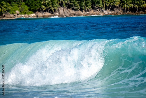 Big turquoise wave on the beautiful tropical paradise beach Anse Intendance at Seychelles, Mahe.