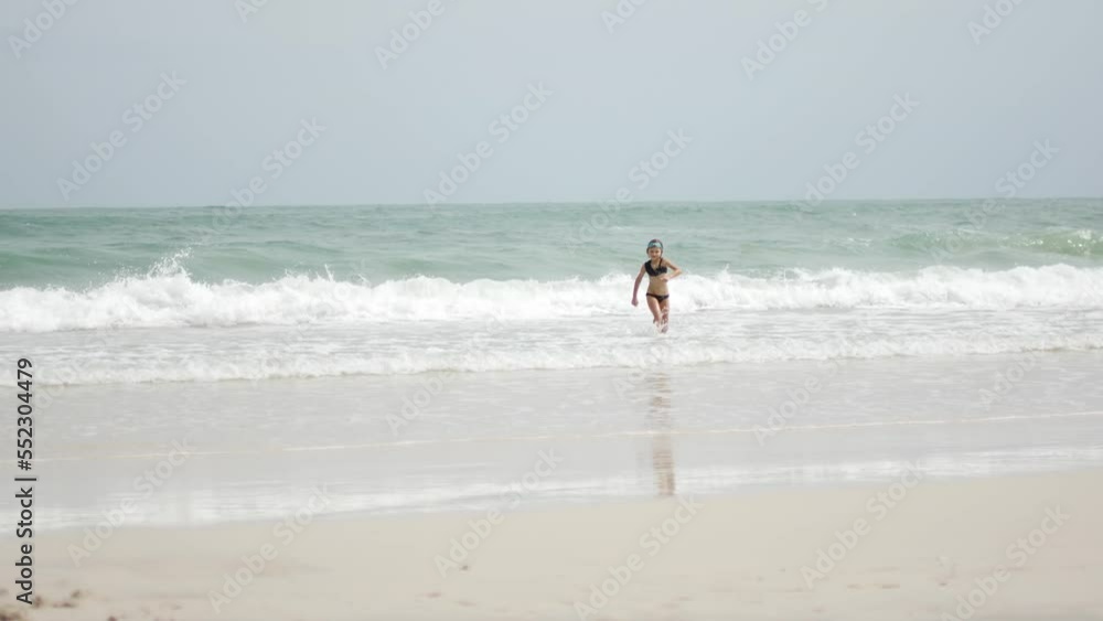 A child plays in the waves near the shore A child plays in the waves near the shore