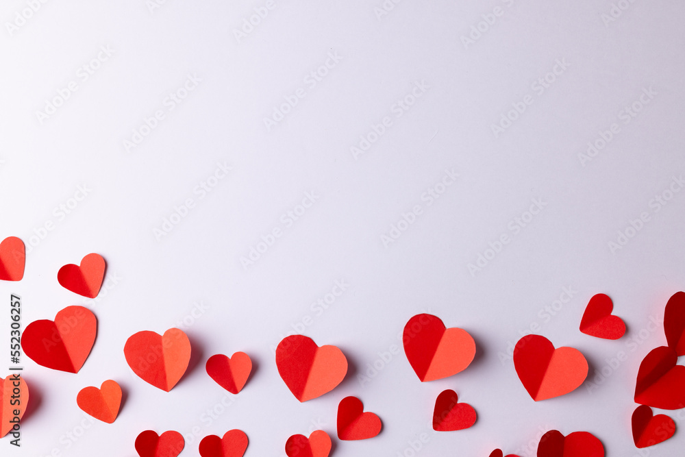 Red paper heart shapes on white background with copy space