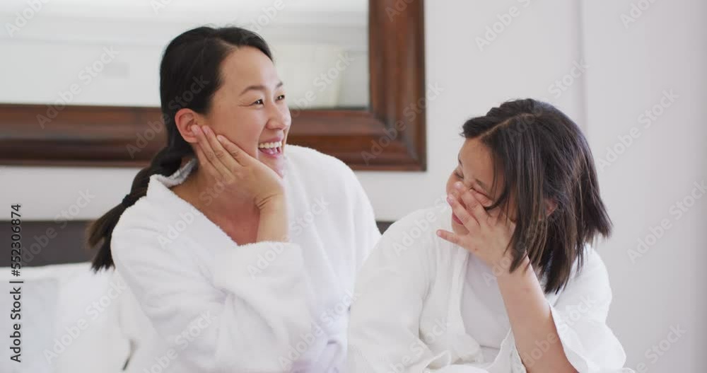 Video of happy asian mother and daughter in robes having fun Video of happy asian mother and daughter in robes having fun