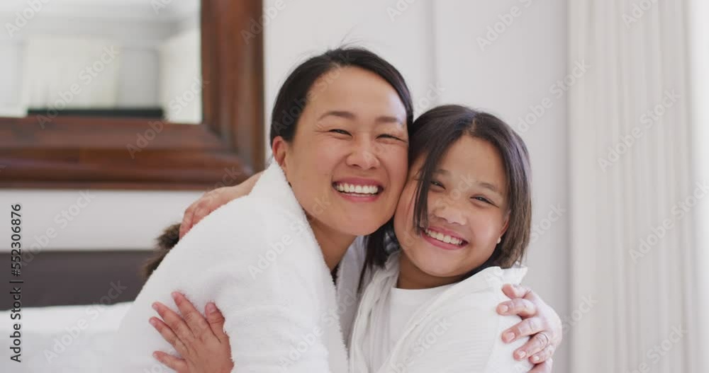 Video of happy asian mother and daughter in robes embracing and having fun Video of happy asian mother and daughter in robes embracing and having fun
