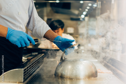 Hand of man take cooking of meat with vegetable grill  Chef cooking wagyu beef in Japanese teppanyaki restaurant