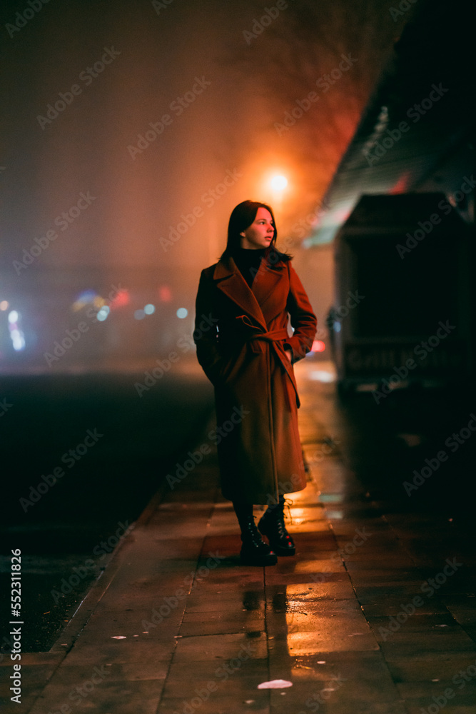 young girl teenager in a long coat walk around the autumn night city young girl teenager in a long coat walk around the autumn night city