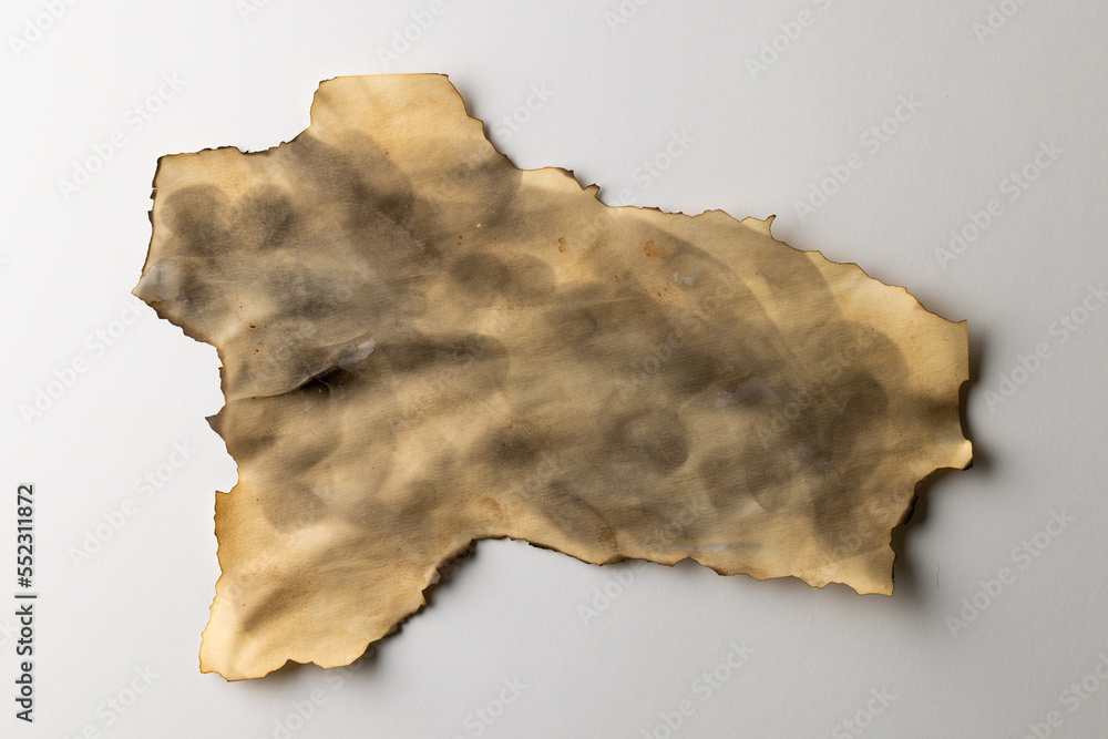 Burned and stained piece of paper with copy space on white background Burned and stained piece of paper with copy space on white background