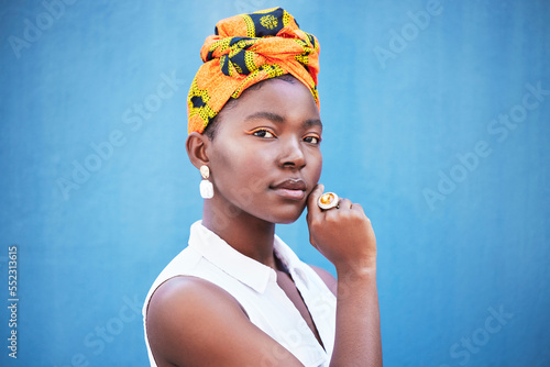 Fototapeta Portrait, black woman and turban with makeup or relax on blue studio background
