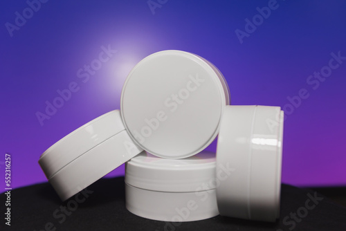 Handy white plastic jar for cosmetics or food on the beautiful background