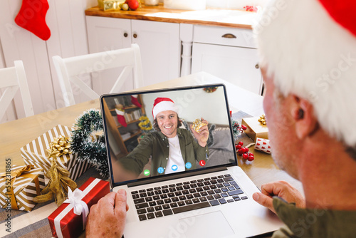 Senior caucasian man having christmas video call with caucasian man © vectorfusionart