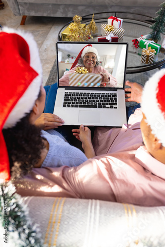 African american couple having christmas video call with senior african american woman