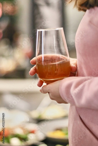 A woman holds a glass with a cocktail in her hand. Traditions of drinking alcohol.