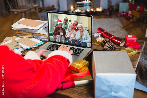 Santa claus having video call with happy senior diverse friends