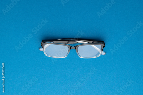 Composition of glasses on blue background with copy space