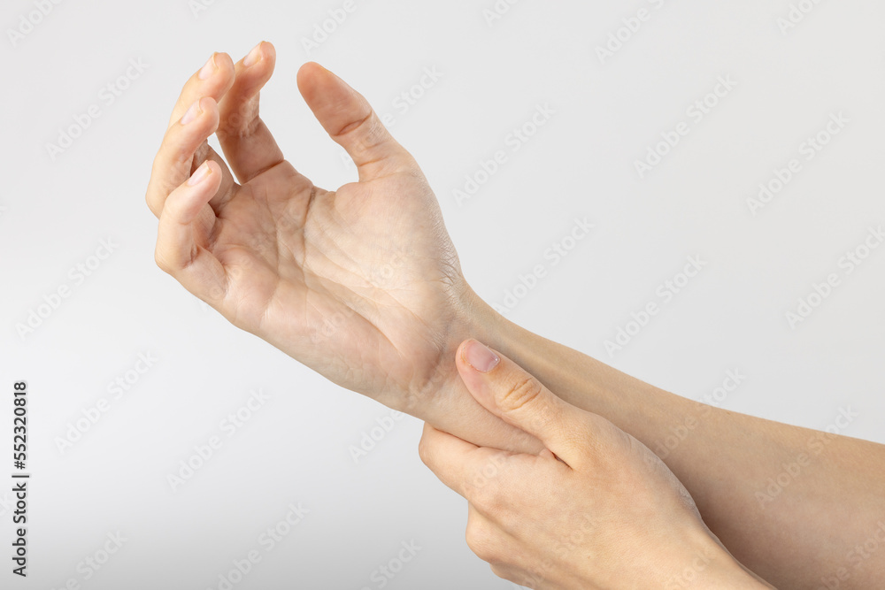 Close up of hands of caucasian woman taking pulse on wrist on white background Close up of hands of caucasian woman taking pulse on wrist on white background