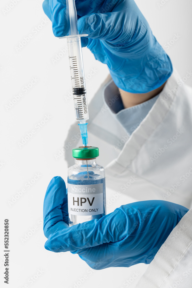 Vertical of doctor's gloved hands filling syringe from hpv vaccine vial, on white with copy space Vertical of doctor's gloved hands filling syringe from hpv vaccine vial, on white with copy space