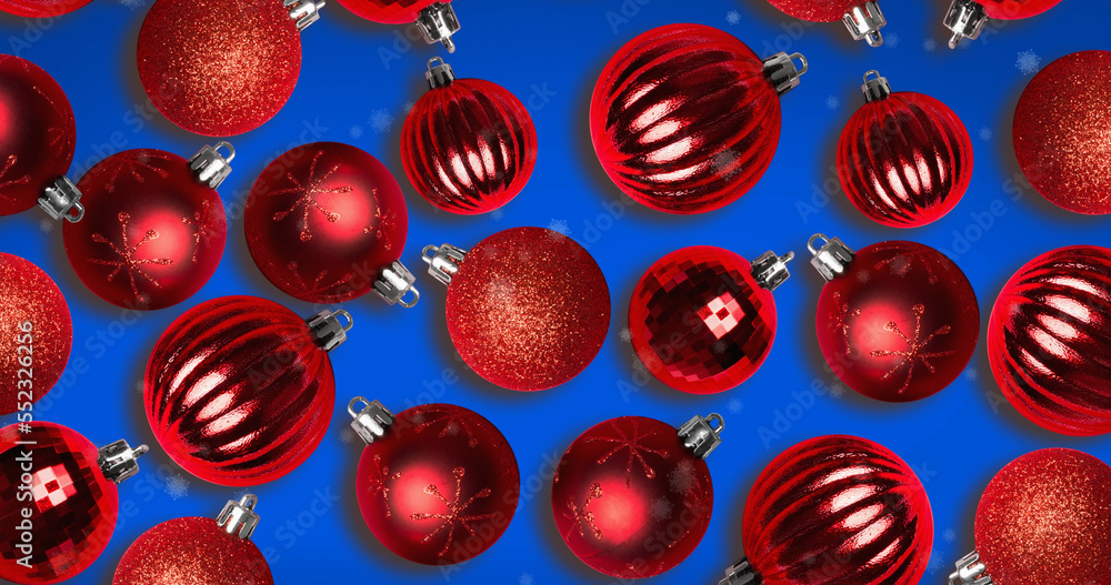 Image of snow falling over christmas bauble decorations on blue background Image of snow falling over christmas bauble decorations on blue background