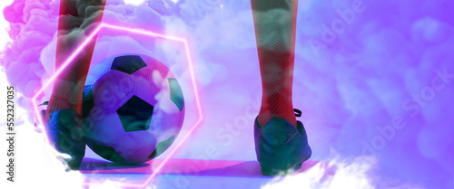 Low section of male player wearing red socks and black shoes with ball and illuminated hexagon