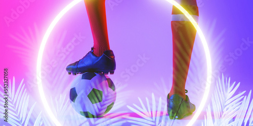 Low section of caucasian male player with leg on ball by illuminated plants and circle, copy space