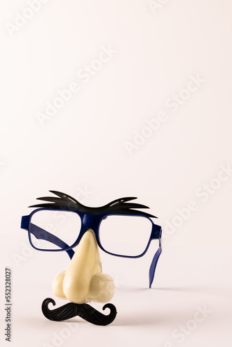 Composition of fake mask with glasses and moustache on white background with copy space