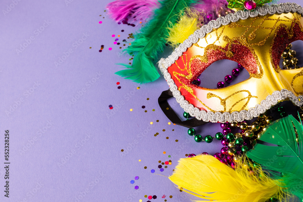 Colourful mardi gras beads, feathers and carnival mask on blue background with copy space - obrazy, fototapety, plakaty 