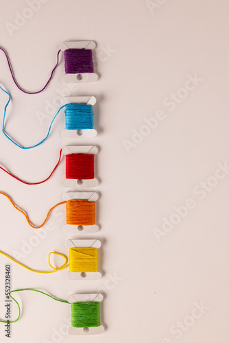 Composition of colourful sewing crewels on white background with copy space