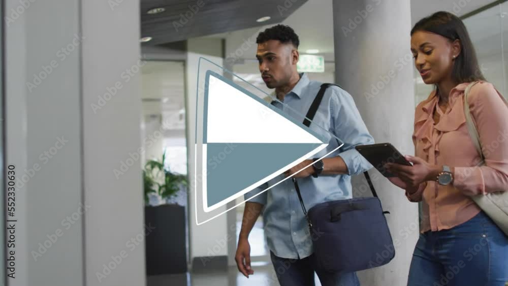 Animation of play digital icon over business people in office Animation of play digital icon over business people in office