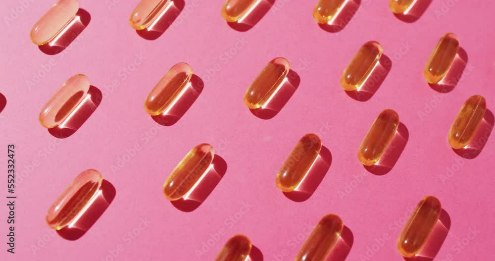 Video of oil capsules arranged in rows on pink background Video of oil capsules arranged in rows on pink background