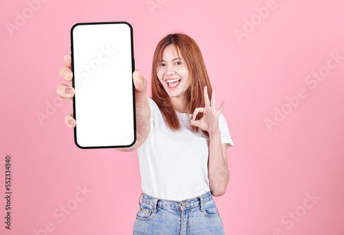 Wallpaper Mural Asian young woman showing smart phone with blank screen , white screen for Mobile App Advertising isolated on pink background ,Cell phone display Mock Up Image. Torontodigital.ca