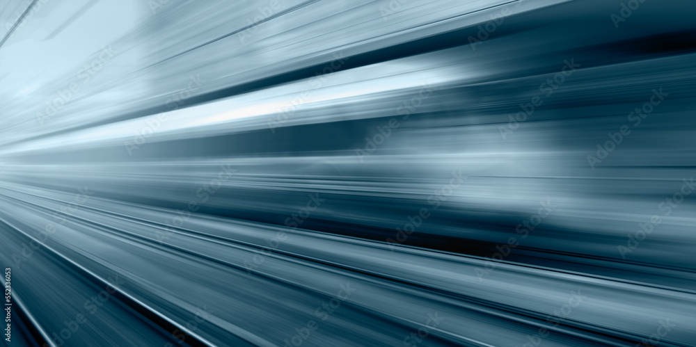Blue high speed train runs on rail tracks - The train is going too fast as a result the air pressure is causing too much heat at the front Blue high speed train runs on rail tracks - The train is going too fast as a result the air pressure is causing too much heat at the front
