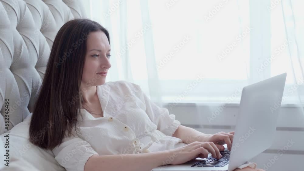 young woman using laptop sitting on bed. people young woman using laptop sitting on bed. people