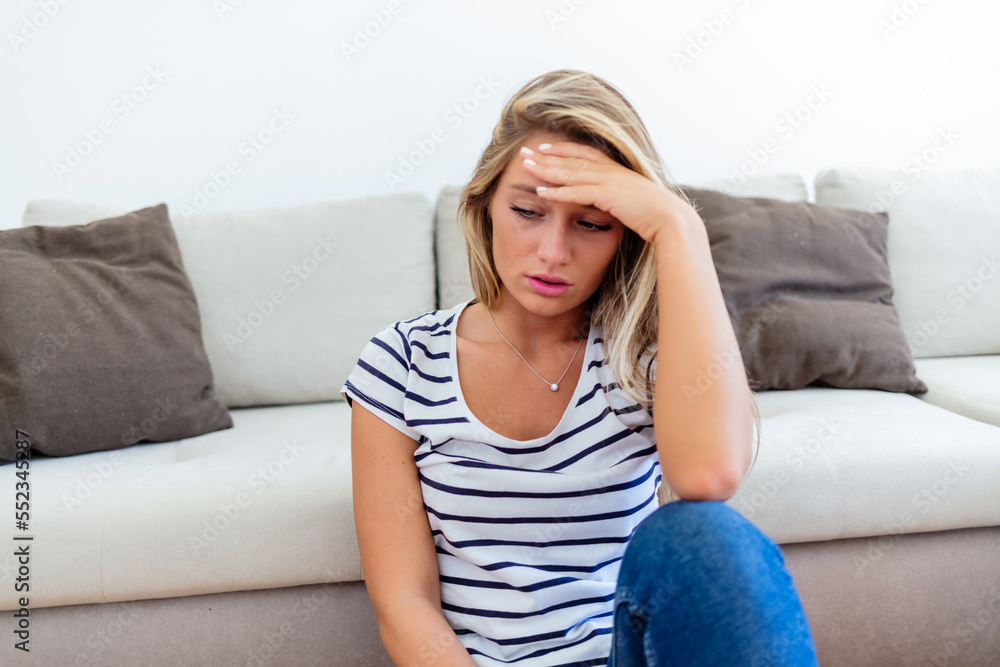Sad, depressed and lonely young woman with mental health problems sitting on floor at home. Portrait of a Caucasian female in depression, stress and anxiety feeling unhappy living alone in a house. Sad, depressed and lonely young woman with mental health problems sitting on floor at home. Portrait of a Caucasian female in depression, stress and anxiety feeling unhappy living alone in a house.