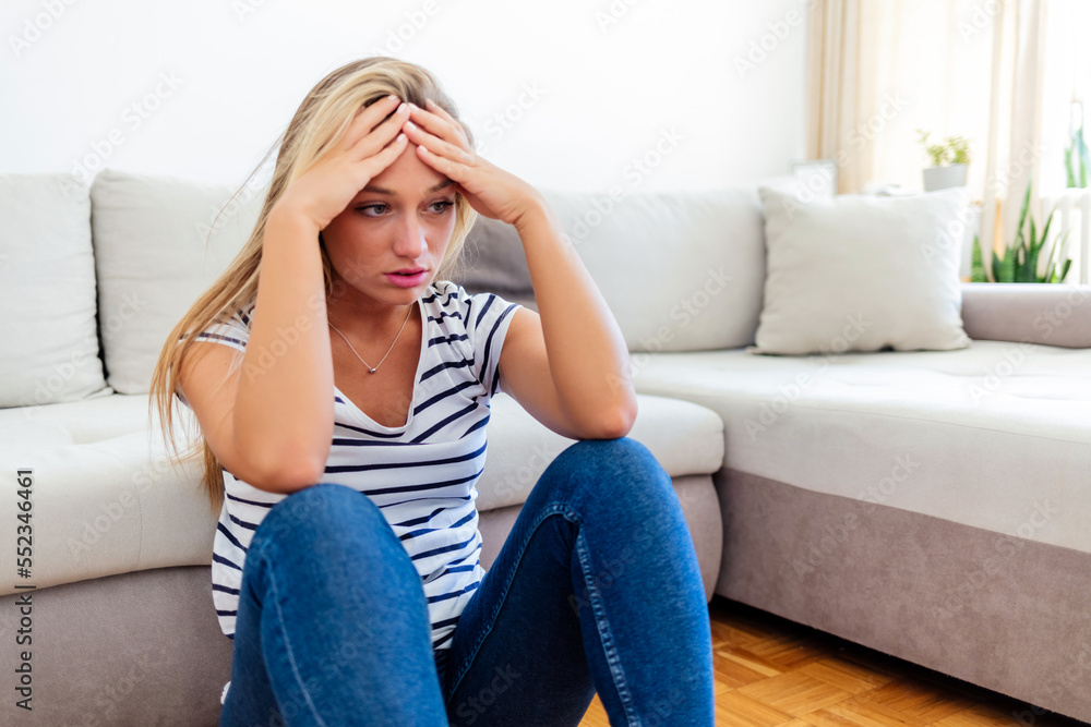 Sad, depressed and lonely young woman with mental health problems sitting on floor at home. Portrait of a Caucasian female in depression, stress and anxiety feeling unhappy living alone in a house. Sad, depressed and lonely young woman with mental health problems sitting on floor at home. Portrait of a Caucasian female in depression, stress and anxiety feeling unhappy living alone in a house.