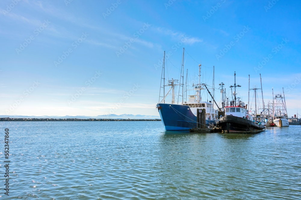 Small fishing trawler and tugboat moored at the ocean pier Small fishing trawler and tugboat moored at the ocean pier