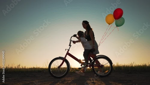Wallpaper Mural Happy family. Mom teaches son to ride bike. Concept of children holiday and dreams. Family playing in park at sunset. Silhouette of mom and son on a bike in the park. Green energy. Mom teaches son. Torontodigital.ca