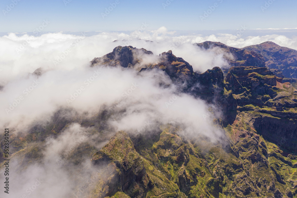 Obraz premium Drone view of mountain peak submerged in fog