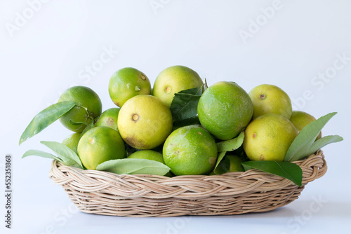 Green lemon in rattan basket for sell at market and supermarket.