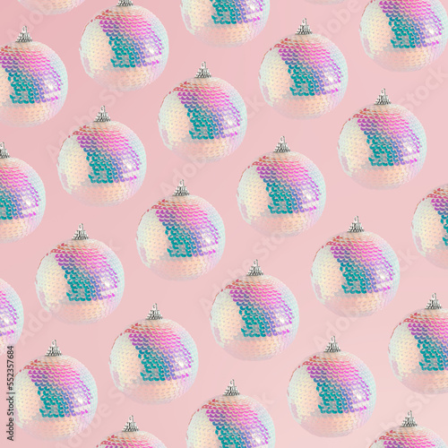 Sparkly disco Christmas bauble ornament on a soft pink background. New Year's countdown moments. Celebration concept pattern idea