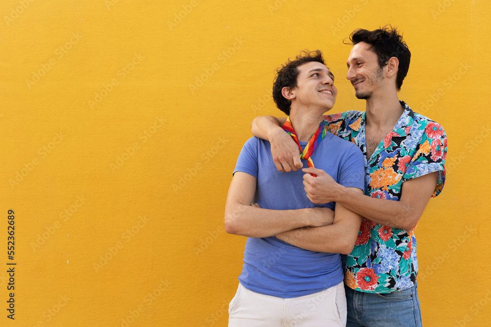 Naklejka premium Happy young couple embraces. Two men enjoy outside.