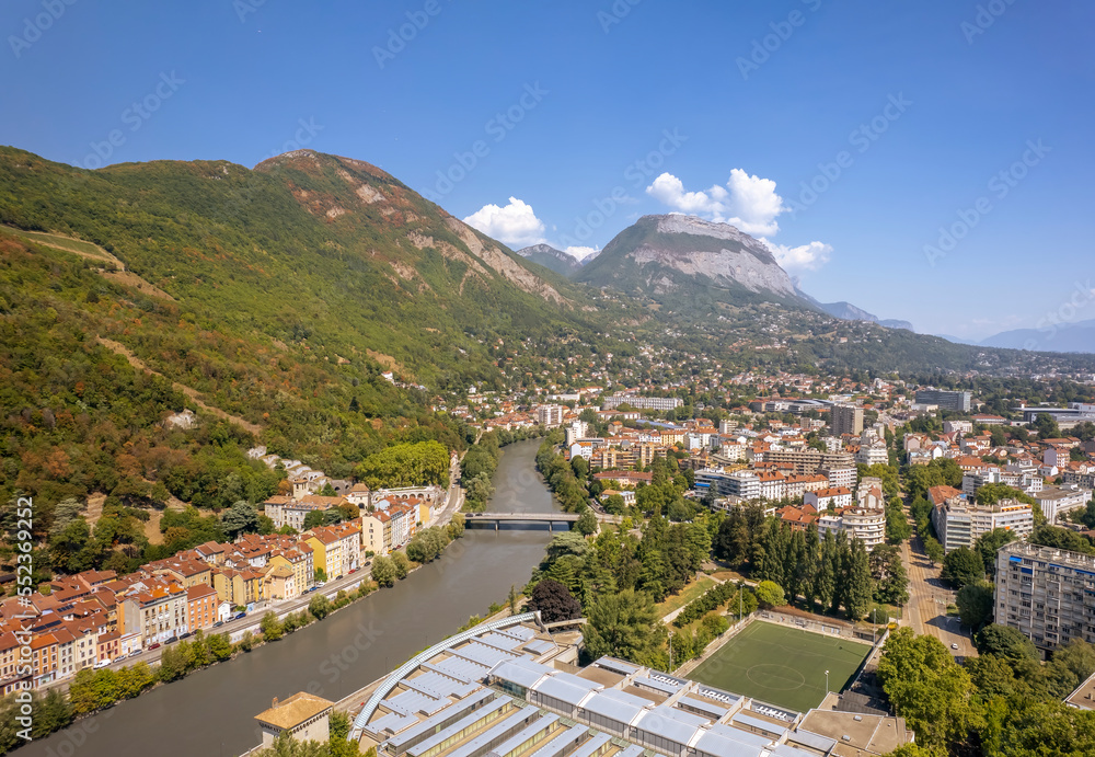 The drone aerial view of the Isère River and Grenoble city, France.  Grenoble is the prefecture and largest city of the Isère department in the Auvergne-Rhône-Alpes region of southeastern France.